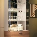 Lit glass display cabinet with a wooden drawer base for a living room